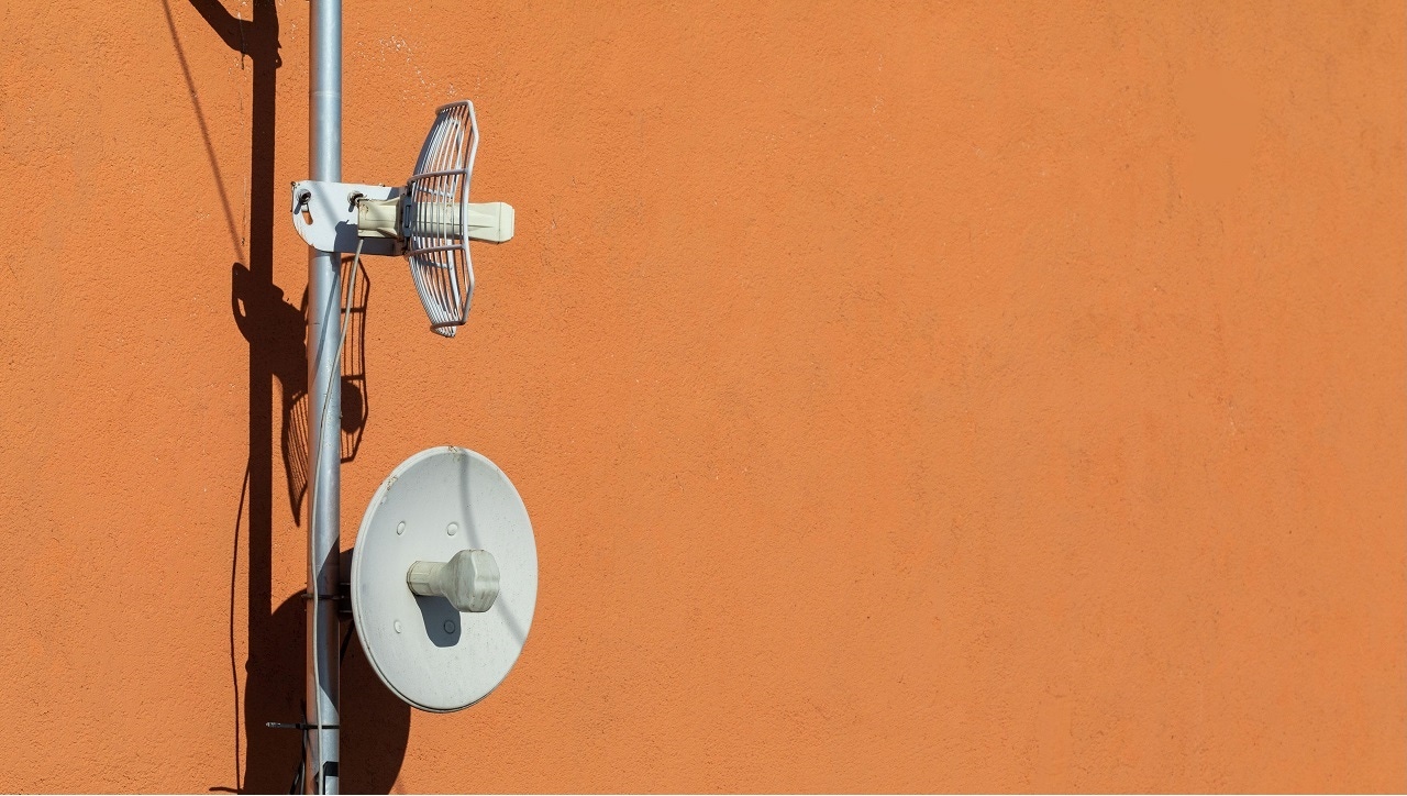 Two telecommunications antennas used for cellular network and wireless Internet, fixed on the building wall.